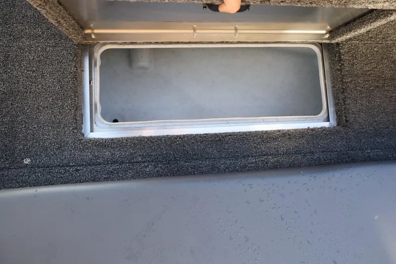 Slide: The Image of 2026 Lowe Fish & Ski 1625 boat storage compartment with open lid. - 38