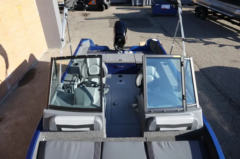 Slide: The Image of 2026 Lowe Fish & Ski 1625 boat with dual windshields and seating, parked outdoors. - 41