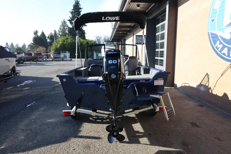 Slide: The Image of 2026 Lowe Fish & Ski 1625 boat with Mercury 60 engine, parked outdoors. - 5