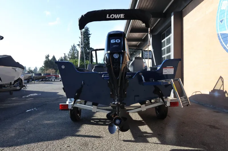 Slide: The Image of 2026 Lowe Fish & Ski 1625 boat with 60 HP engine, parked outdoors. - 6