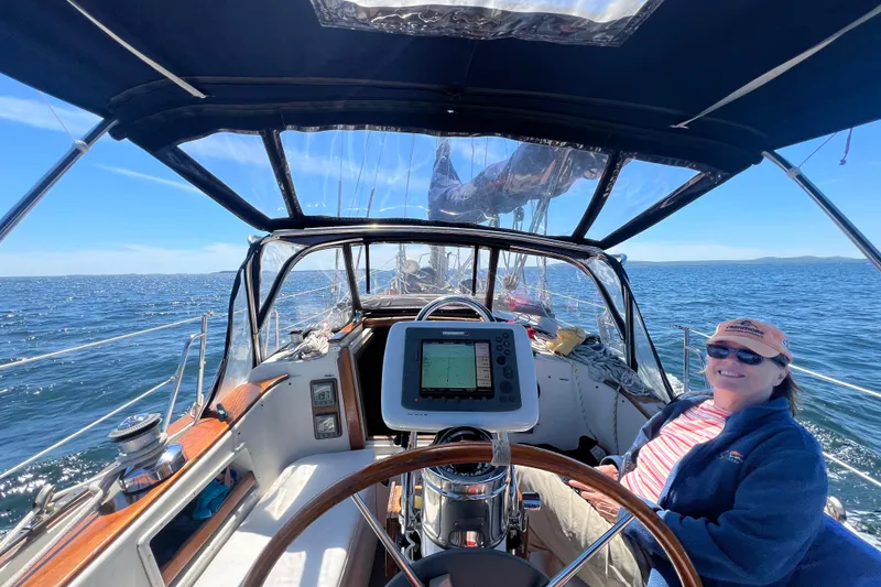 Slide: The Image of 1982 Pacific Seacraft 37 sailboat cockpit with a smiling person, open sea view. - 11