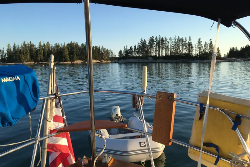 Slide: The Image of Sailboat view from 1982 Pacific Seacraft 37, serene lake, forested island background. - 22
