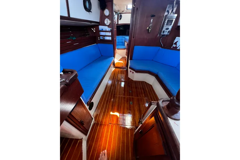 Slide: The Image of Interior of 1982 Pacific Seacraft 37 sailboat with polished wood and blue seating. - 32