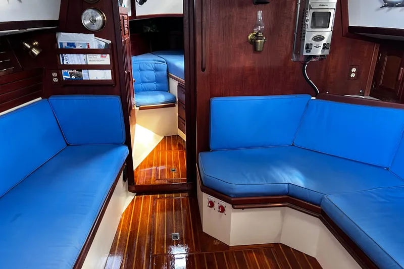 Slide: The Image of Interior of 1982 Pacific Seacraft 37 sailboat with blue cushions and wooden flooring. - 33