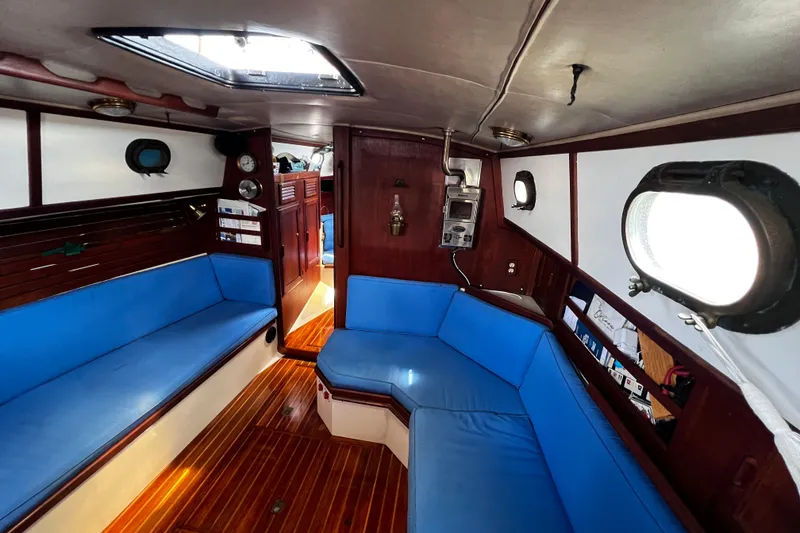 Slide: The Image of Interior of 1982 Pacific Seacraft 37 sailboat with blue seating and wooden flooring. - 34