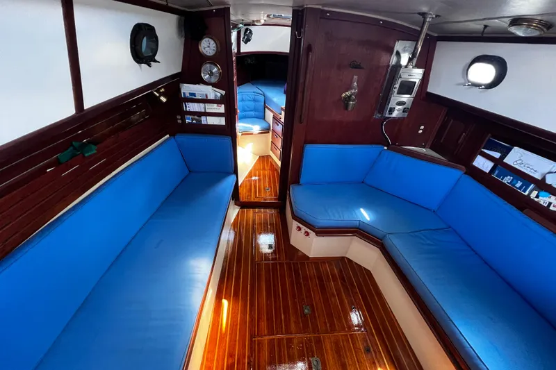 Slide: The Image of Interior of 1982 Pacific Seacraft 37 sailboat with blue seating and wooden flooring. - 35