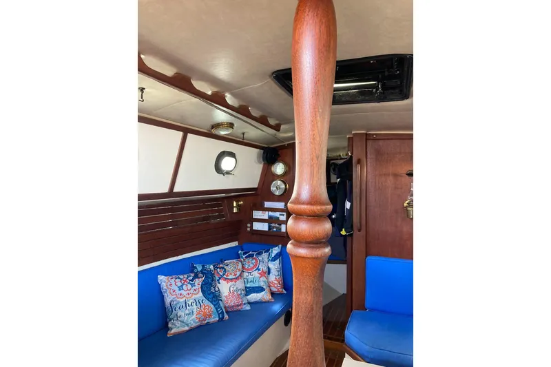 Slide: The Image of Interior of 1982 Pacific Seacraft 37 sailboat with blue seating and decorative pillows. - 38