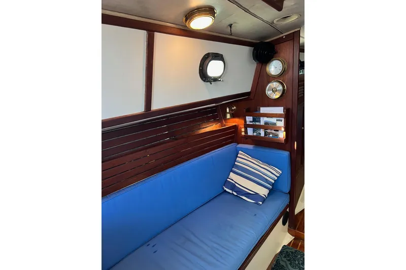 Slide: The Image of Interior of 1982 Pacific Seacraft 37 sailboat with blue cushioned seating and nautical decor. - 39