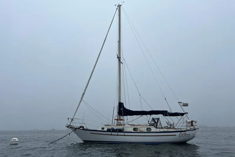 Slide: The Image of 1982 Pacific Seacraft 37 sailboat on calm water under overcast sky. - 4
