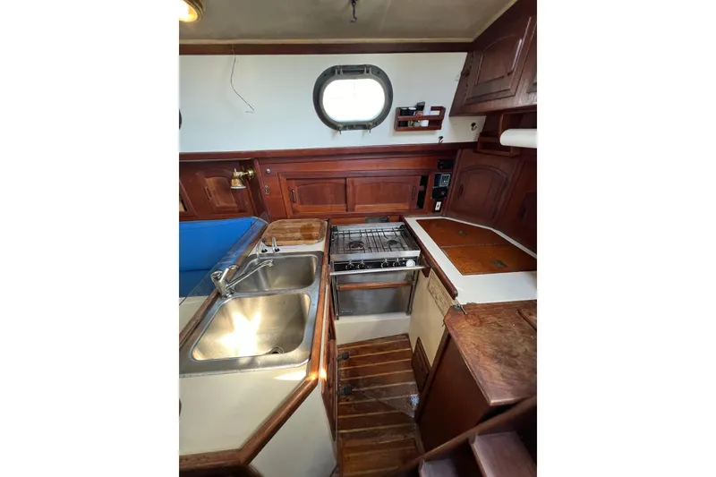 Slide: The Image of 1982 Pacific Seacraft 37 yacht interior kitchen with wooden cabinetry and stainless steel sink. - 41