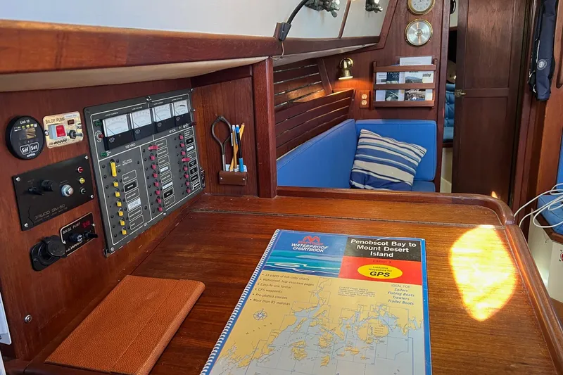Slide: The Image of Navigation station inside a 1982 Pacific Seacraft 37 sailboat with chartbook and control panel. - 42