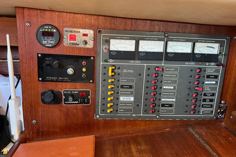 Slide: The Image of Electrical control panel of a 1982 Pacific Seacraft 37 sailboat, featuring various switches and gauges. - 43