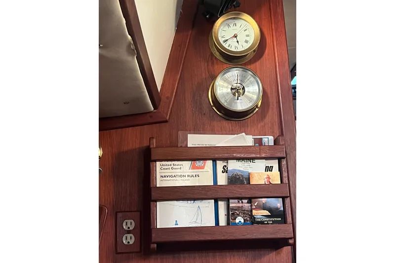 Slide: The Image of Nautical interior of 1982 Pacific Seacraft 37 with clock, barometer, and navigation books. - 50