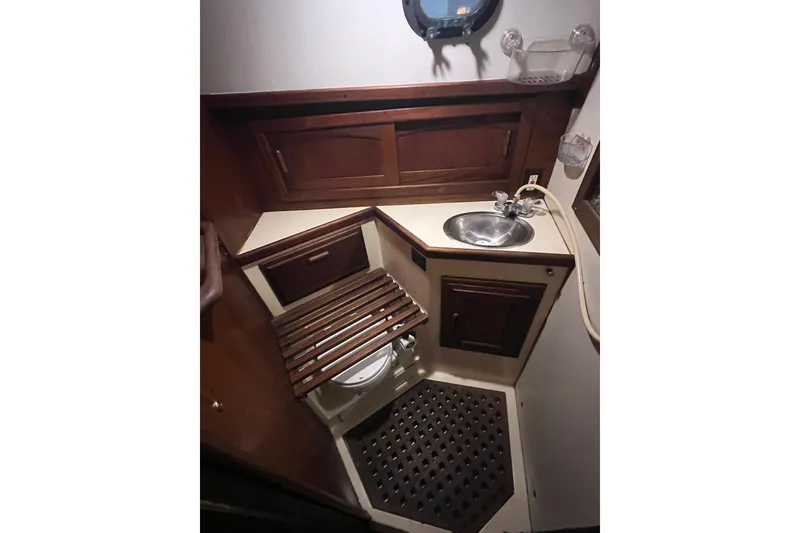 Slide: The Image of 1982 Pacific Seacraft 37 yacht bathroom with wooden cabinetry and compact sink. - 51