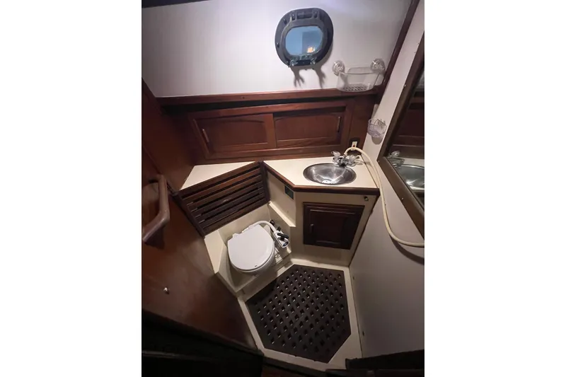 Slide: The Image of 1982 Pacific Seacraft 37 yacht bathroom with wooden accents and porthole window. - 52
