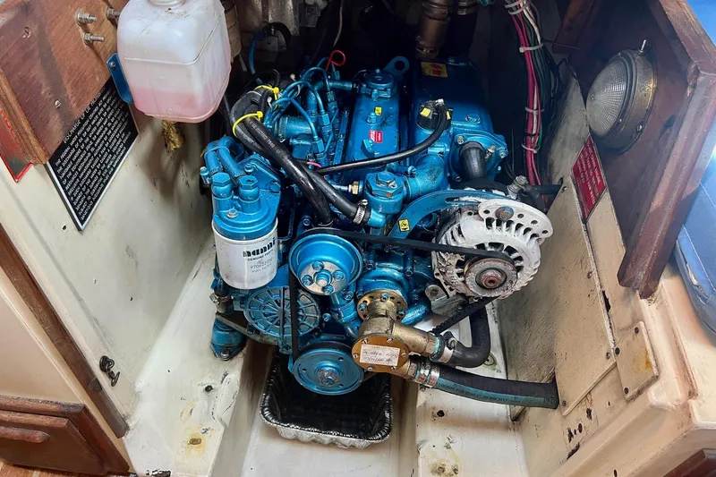 Slide: The Image of Engine compartment of a 1982 Pacific Seacraft 37 sailboat, featuring a blue marine engine. - 53