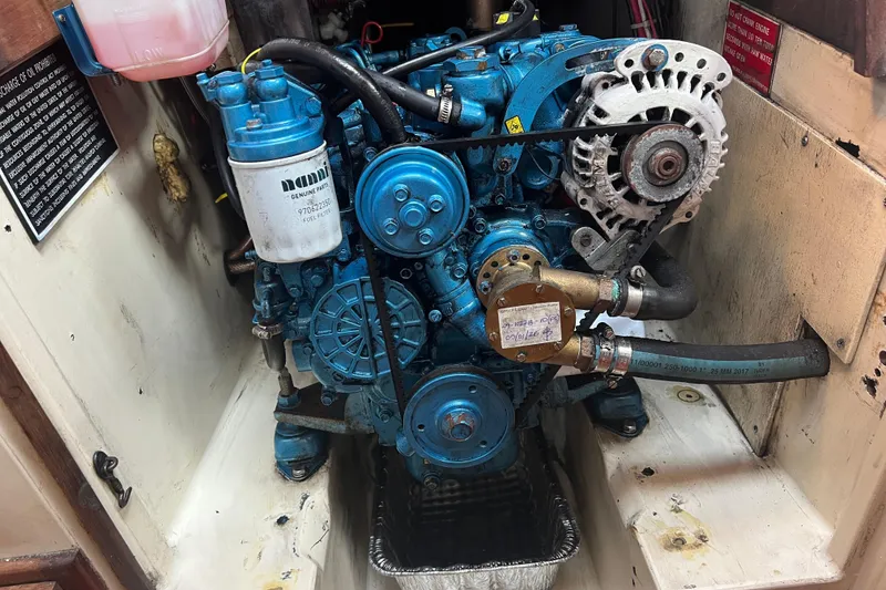 Slide: The Image of Engine compartment of a 1982 Pacific Seacraft 37 sailboat, featuring a blue marine engine. - 54