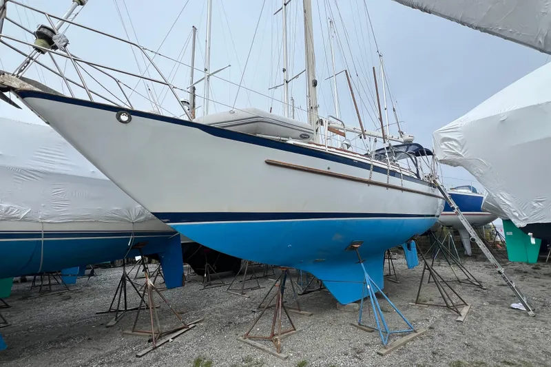 Slide: The Image of 1982 Pacific Seacraft 37 sailboat on stands, blue hull, in a boatyard. - 7
