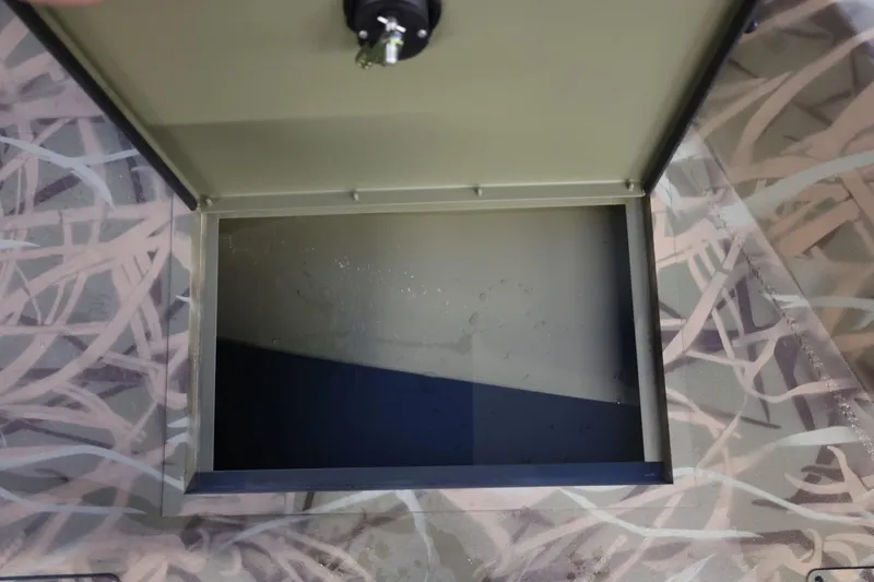 Slide: The Image of Open storage compartment on 2026 Lund 1870 Predator CC boat with camouflage pattern. - 14