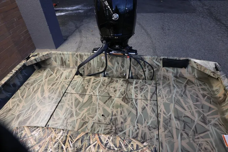 Slide: The Image of 2026 Lund 1870 Predator CC boat with camouflage interior and outboard motor. - 2