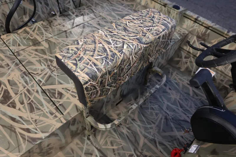 Slide: The Image of 2026 Lund 1870 Predator CC boat interior with camouflage seating and steering wheel. - 8