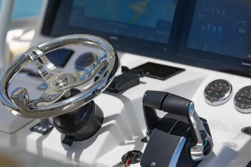 Slide: The Image of 2024 Blackwater 43 Sportfish helm with chrome steering wheel and advanced controls. - 25