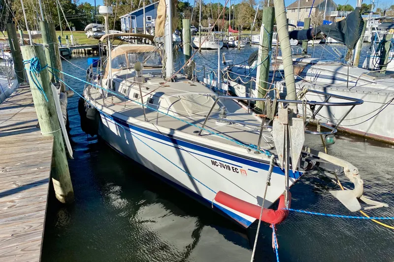 The Image of 1987 O'Day 34 sailboat docked at a marina, surrounded by other boats. - 1