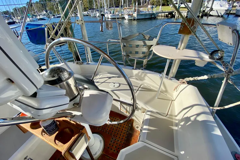 Slide: The Image of Cockpit of 1987 O'Day 34 sailboat with steering wheel and marina view. - 10