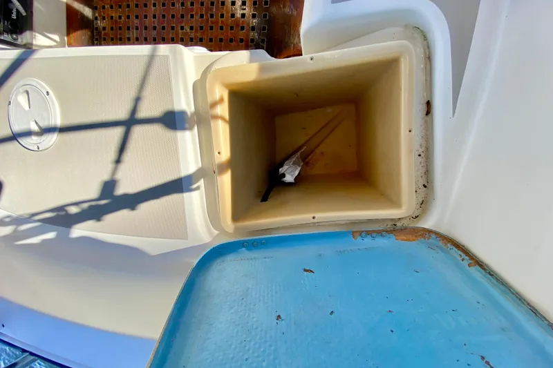 Slide: The Image of 1987 O'Day 34 sailboat cockpit storage compartment with open lid and visible shadows. - 11