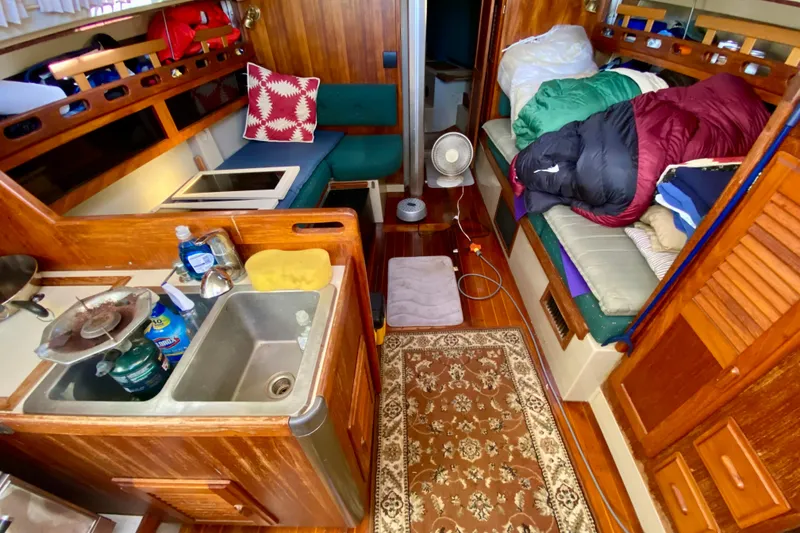 Slide: The Image of Interior of a 1987 O'Day 34 sailboat with cozy living space and kitchenette. - 13