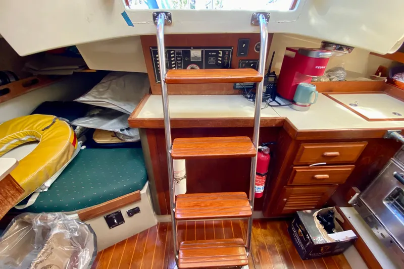 Slide: The Image of Interior of a 1987 O'Day 34 sailboat with wooden steps and kitchenette. - 17