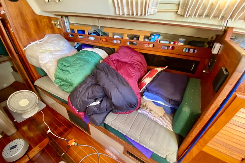 Slide: The Image of Interior of 1987 O'Day 34 sailboat with cushions, fan, and storage items. - 19