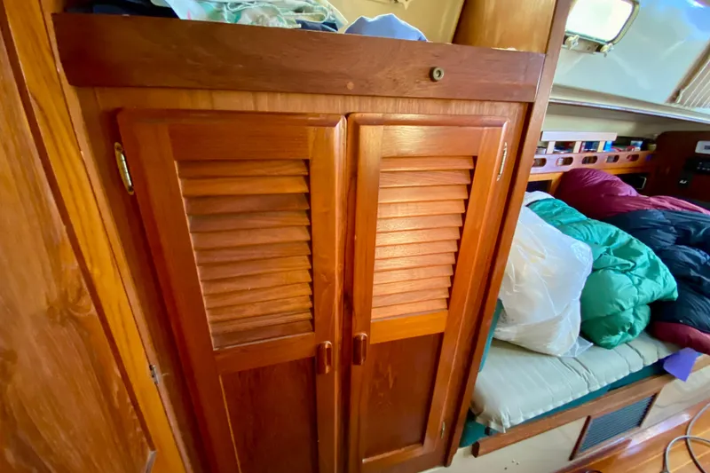 Slide: The Image of 1987 O'Day 34 sailboat interior with wooden cabinet and cozy bedding. - 20