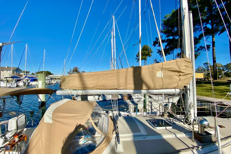 Slide: The Image of 1987 O'Day 34 sailboat docked, featuring beige sail cover and clear blue sky. - 5