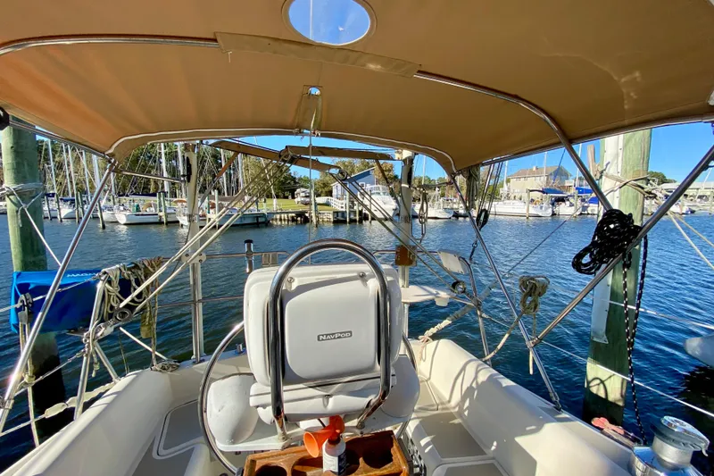 Slide: The Image of 1987 O'Day 34 sailboat cockpit with steering wheel, docked in a marina. - 7