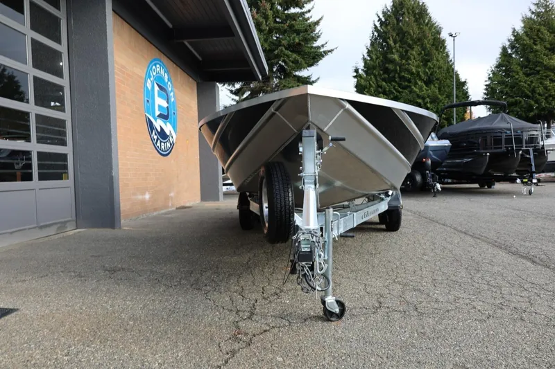 Slide: The Image of 2026 Thunder Jet 229 Rush OT boat on trailer at dealership, surrounded by trees. - 12