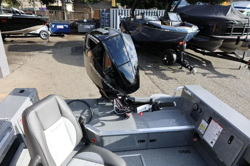 Slide: The Image of 2026 Thunder Jet 229 Rush OT boat with Mercury outboard motor, parked outdoors. - 22