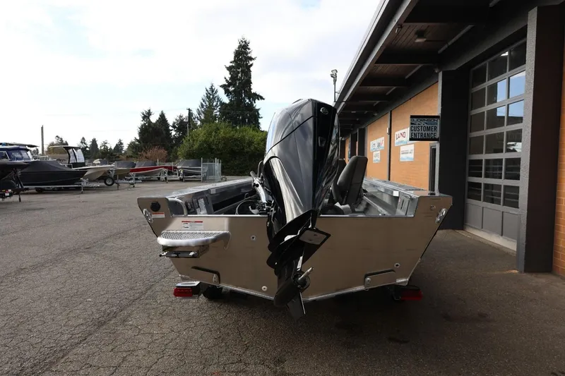 Slide: The Image of 2026 Thunder Jet 229 Rush OT boat with outboard motor, parked outside a dealership. - 5