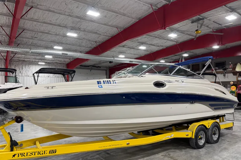 The Image of 2004 Sea Ray 270 Sundeck boat on yellow trailer in indoor storage facility. - 1