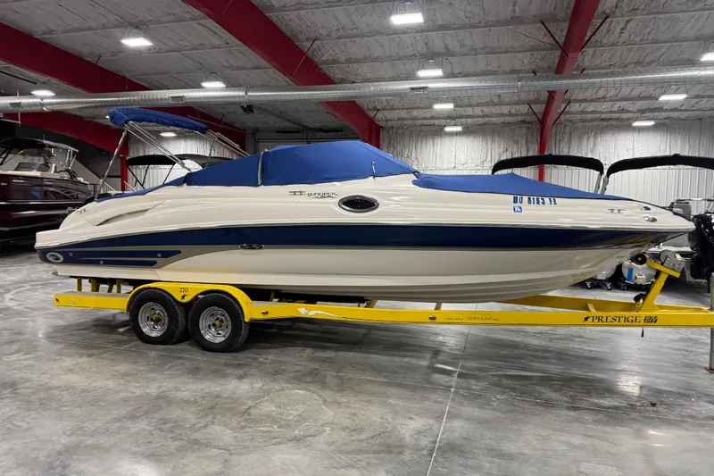 Slide: The Image of 2004 Sea Ray 270 Sundeck boat on yellow trailer in indoor showroom. - 11
