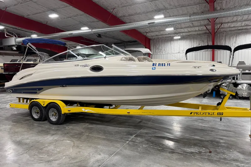 Slide: The Image of 2004 Sea Ray 270 Sundeck boat on yellow trailer in indoor showroom. - 2