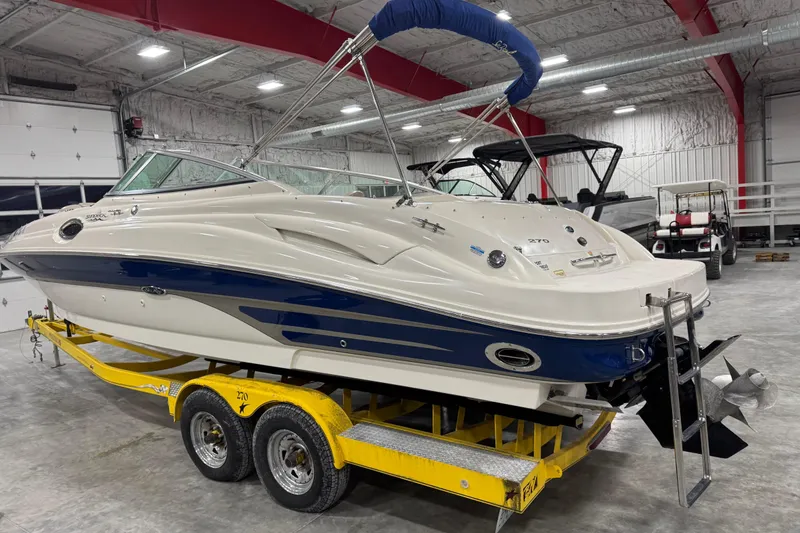 Slide: The Image of 2004 Sea Ray 270 Sundeck boat on yellow trailer in indoor storage facility. - 3