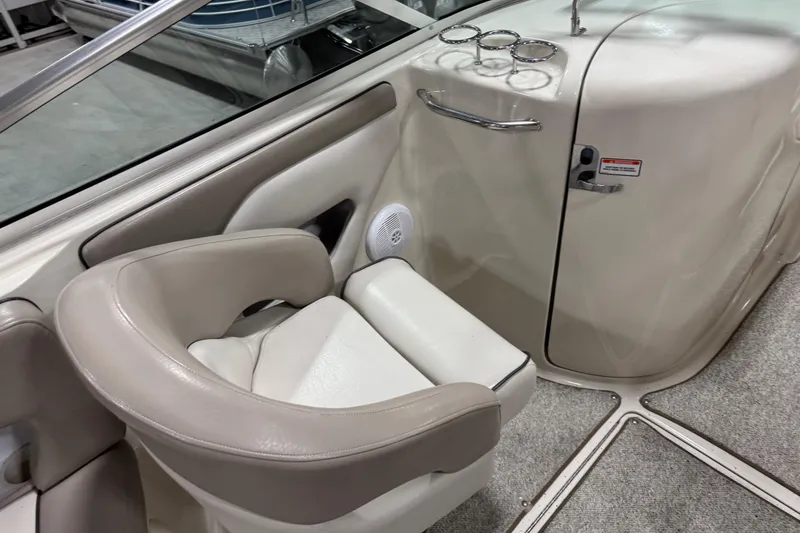 Slide: The Image of 2004 Sea Ray 270 Sundeck interior with beige seating and cup holders. - 9
