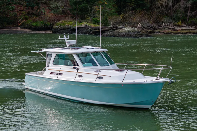 Slide: The Image of 2008 Back Cove 33 boat cruising on a serene green waterway. - 1