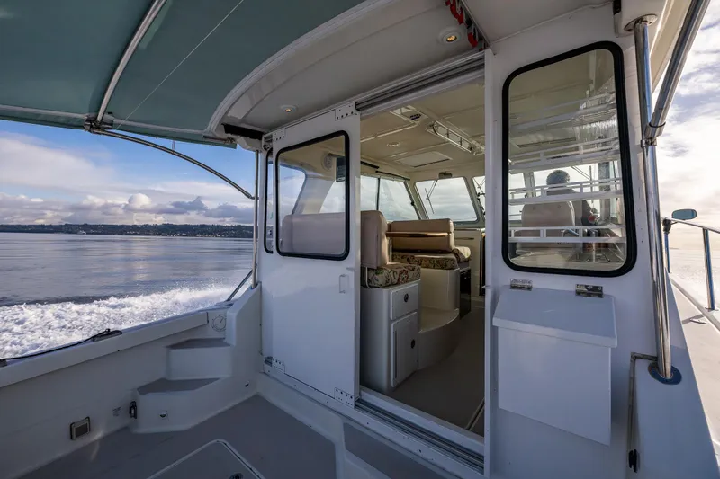 Slide: The Image of 2008 Back Cove 33 boat interior with open cabin door, overlooking calm waters. - 18