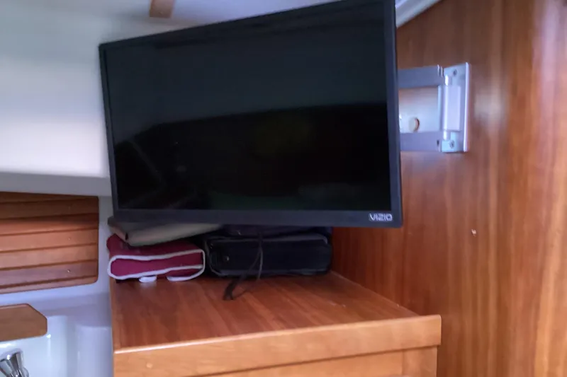 Slide: The Image of 2008 Back Cove 33 interior with mounted Vizio TV on wooden cabinet. - 34