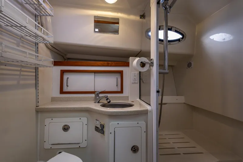 Slide: The Image of 2008 Back Cove 33 yacht bathroom with sink, shower, and storage shelves. - 38