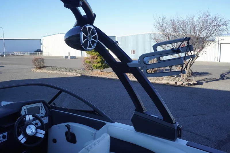 Slide: The Image of 2018 Tigé R22 boat interior with steering wheel, speaker, and wakeboard rack. - 21