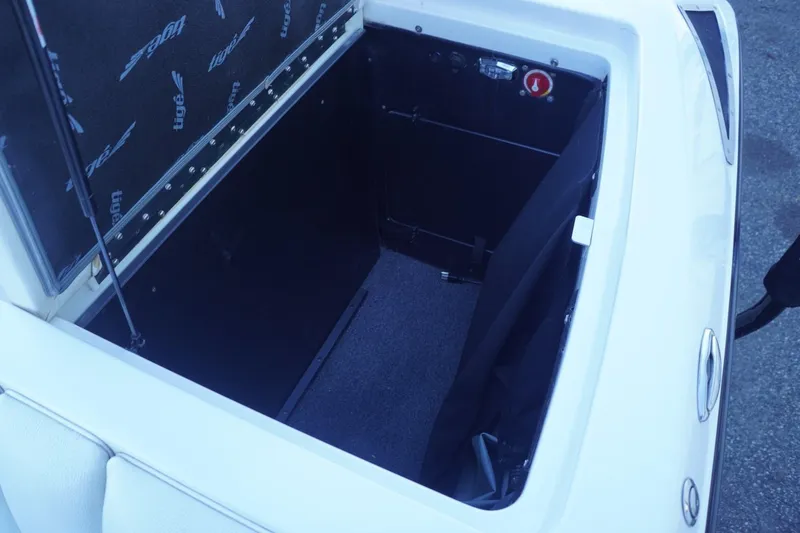 Slide: The Image of Open storage compartment in 2018 Tigé R22 boat, featuring interior details and branding. - 23