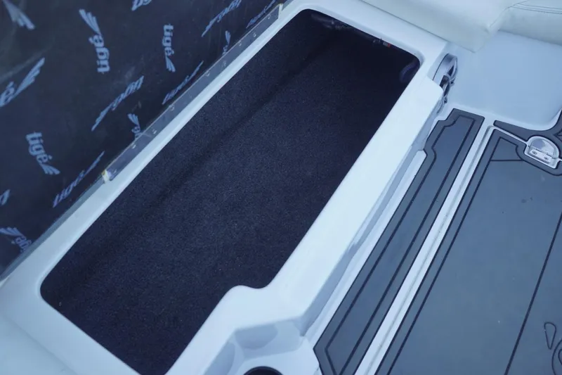 Slide: The Image of 2018 Tigé R22 boat storage compartment with black interior and branded cover. - 26